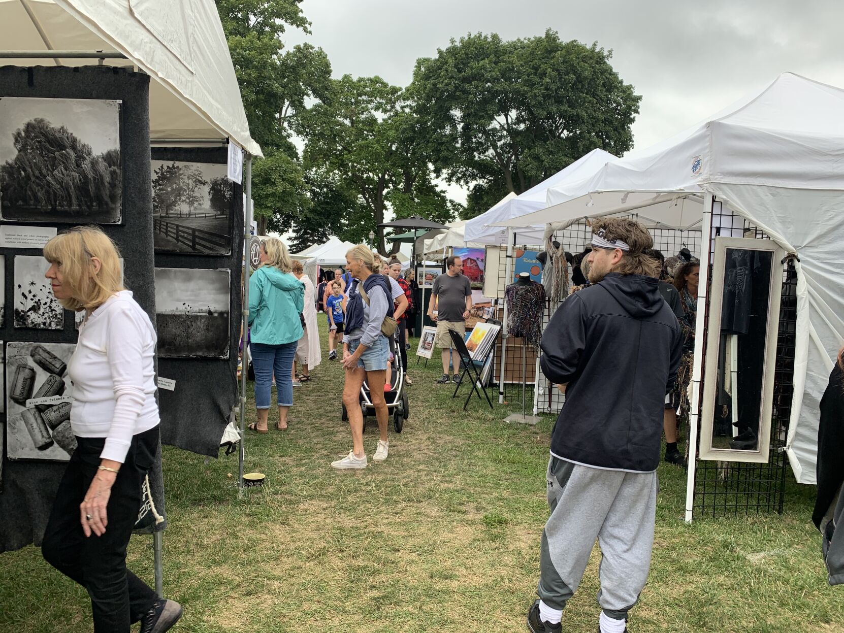 A crowd of people enjoy the artwork and festivities of Art in the Park